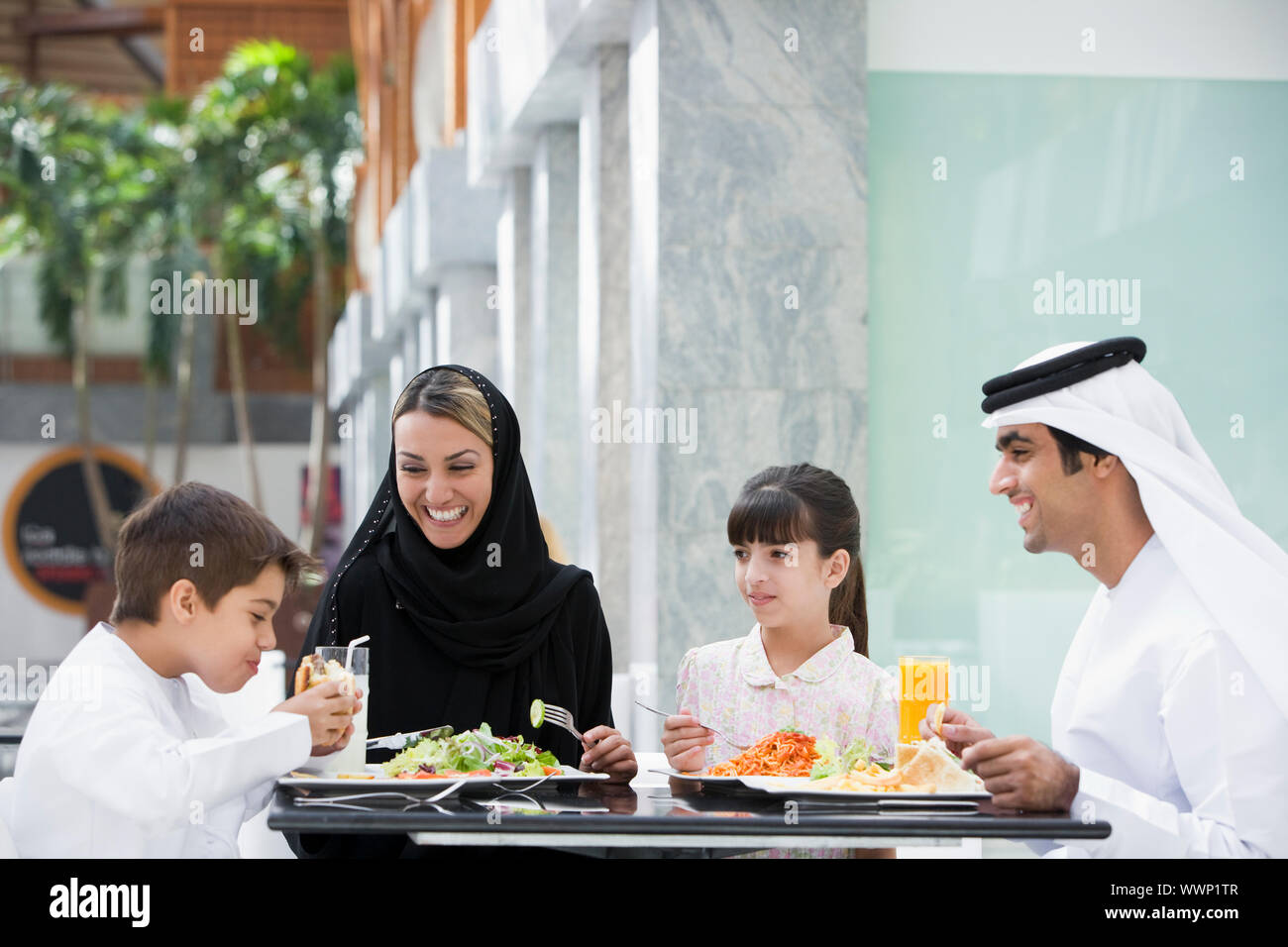 Famiglia al ristorante per mangiare e sorridente (messa a fuoco selettiva) Foto Stock