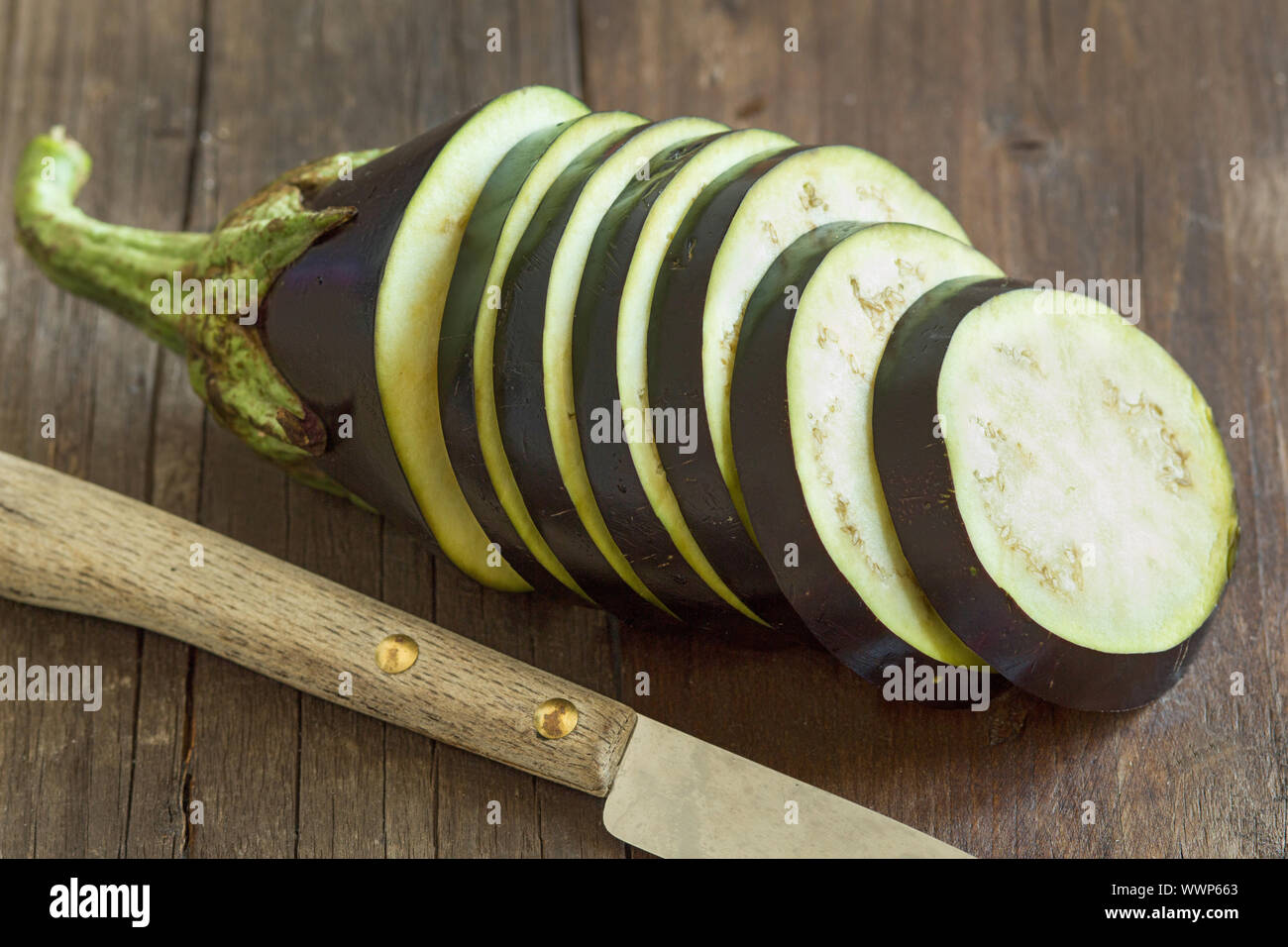 Crudo fresco melanzane con coltello sullo sfondo di legno Foto stock - Alamy