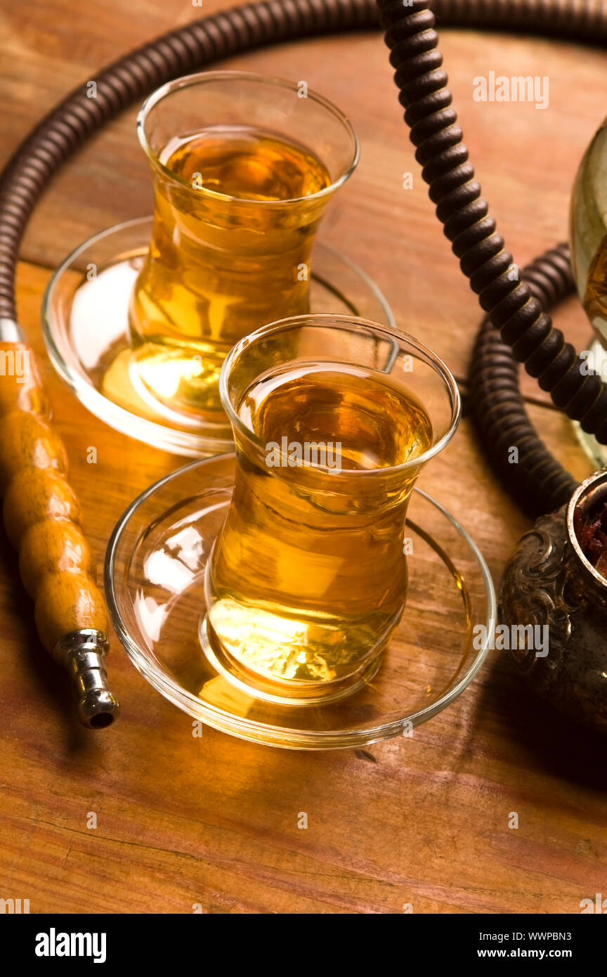 Tazza di tè turco e narghilè serviti in stile tradizionale Foto Stock