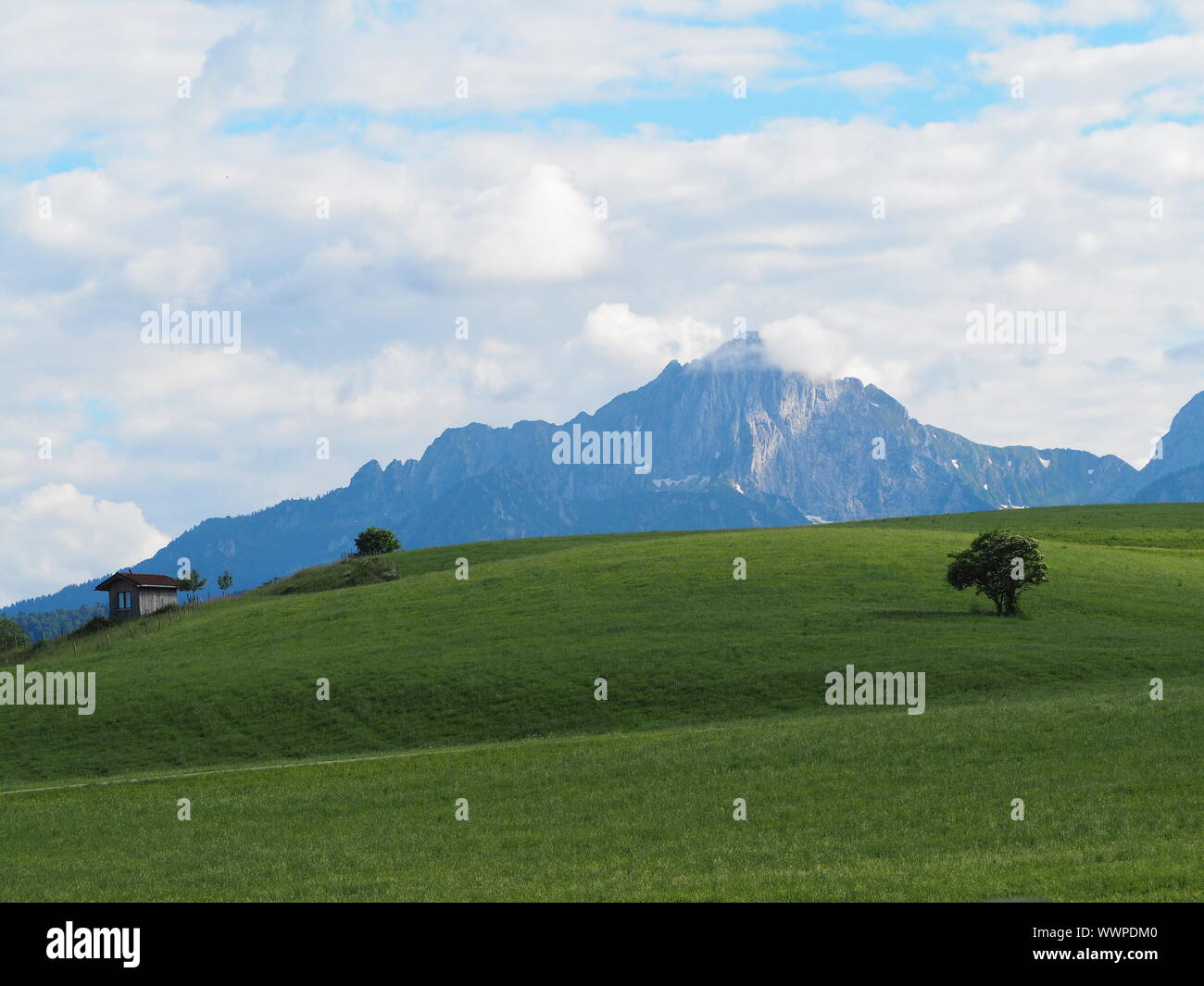 Un rifugio in cima a una collina e montagna in distanza Foto Stock