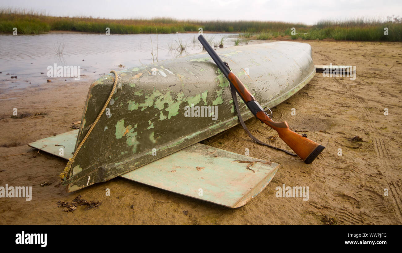 Principali attrezzature di modesto cacciatore di anatre - canoa e il fucile da caccia Foto Stock