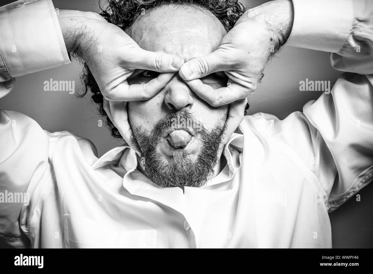 La fantasia e la follia, uomo con intensa espressione, camicia bianca Foto Stock