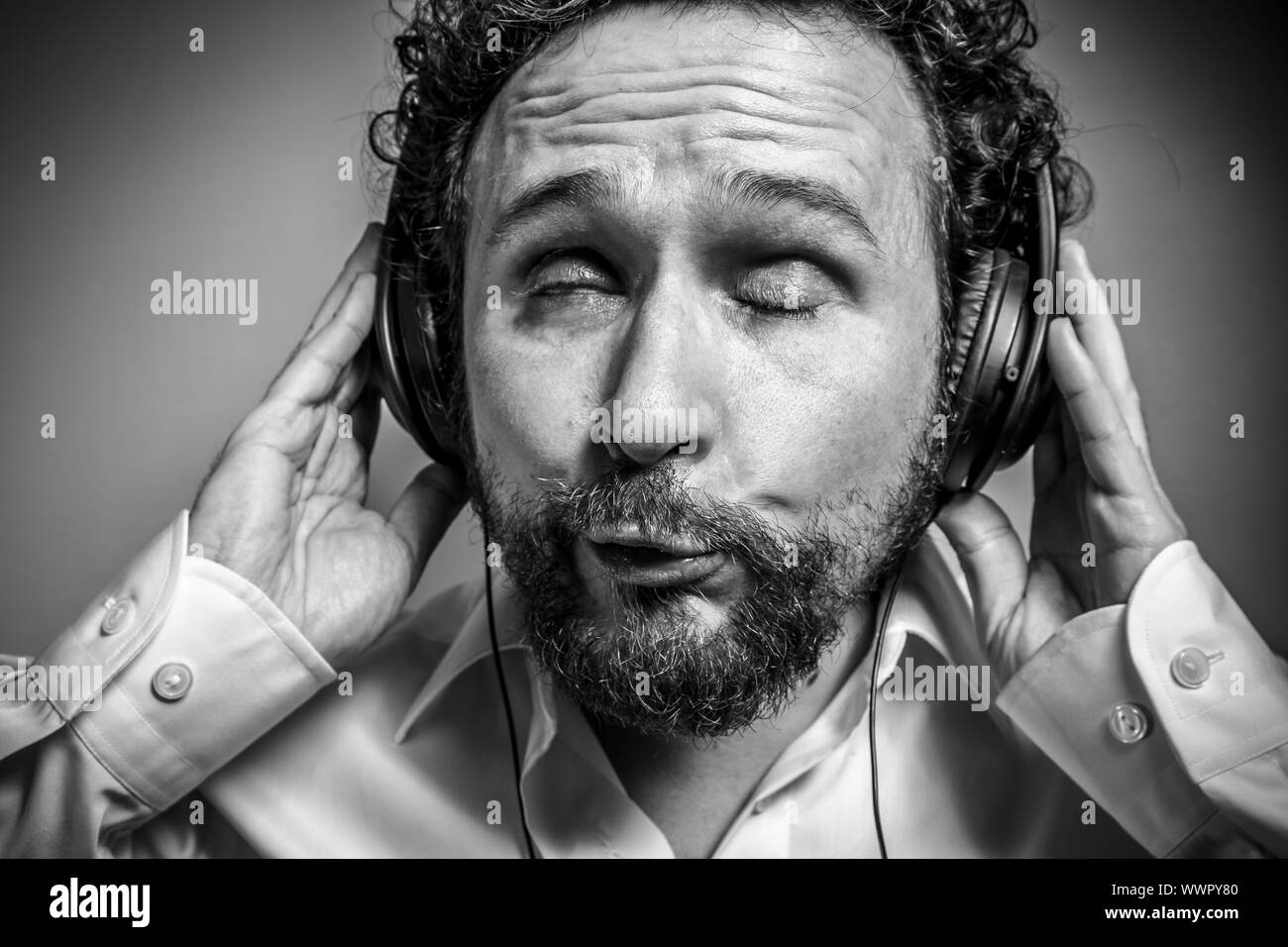 Godetevi la musica, l'uomo con intensa espressione, camicia bianca Foto Stock