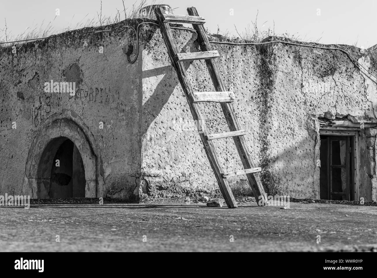 Casa in vendita. Scaletta di legno magra contro una casa di villaggio Sivas a Creta Foto Stock