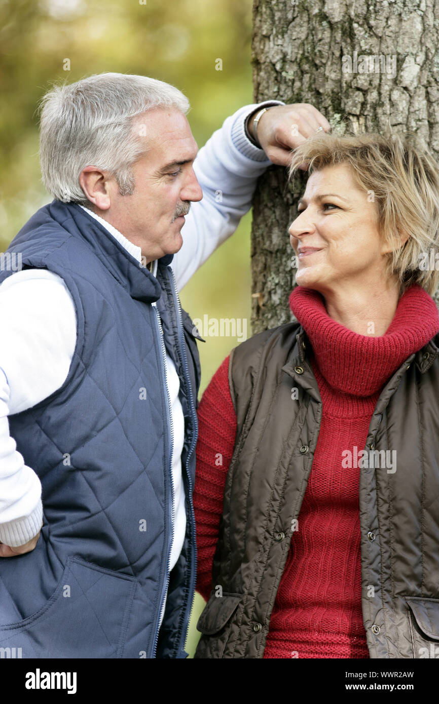 Amare giovane in piedi da una struttura ad albero Foto Stock