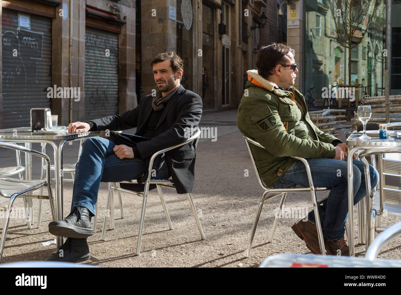 Gli uomini godetevi il sole di giorno fuori da un bar in Plaça de Jaume de Sabartes a Barcellona Foto Stock