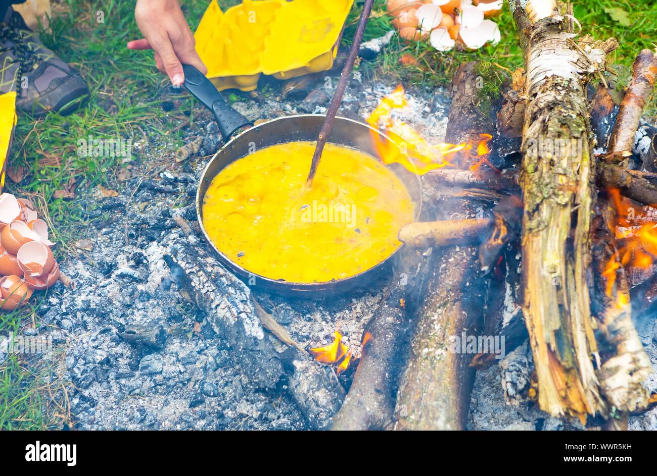 Per la cottura sul fuoco. Preparazione di uova strapazzate sul fuoco naturale. La prima colazione al tour di trekking. Foto Stock