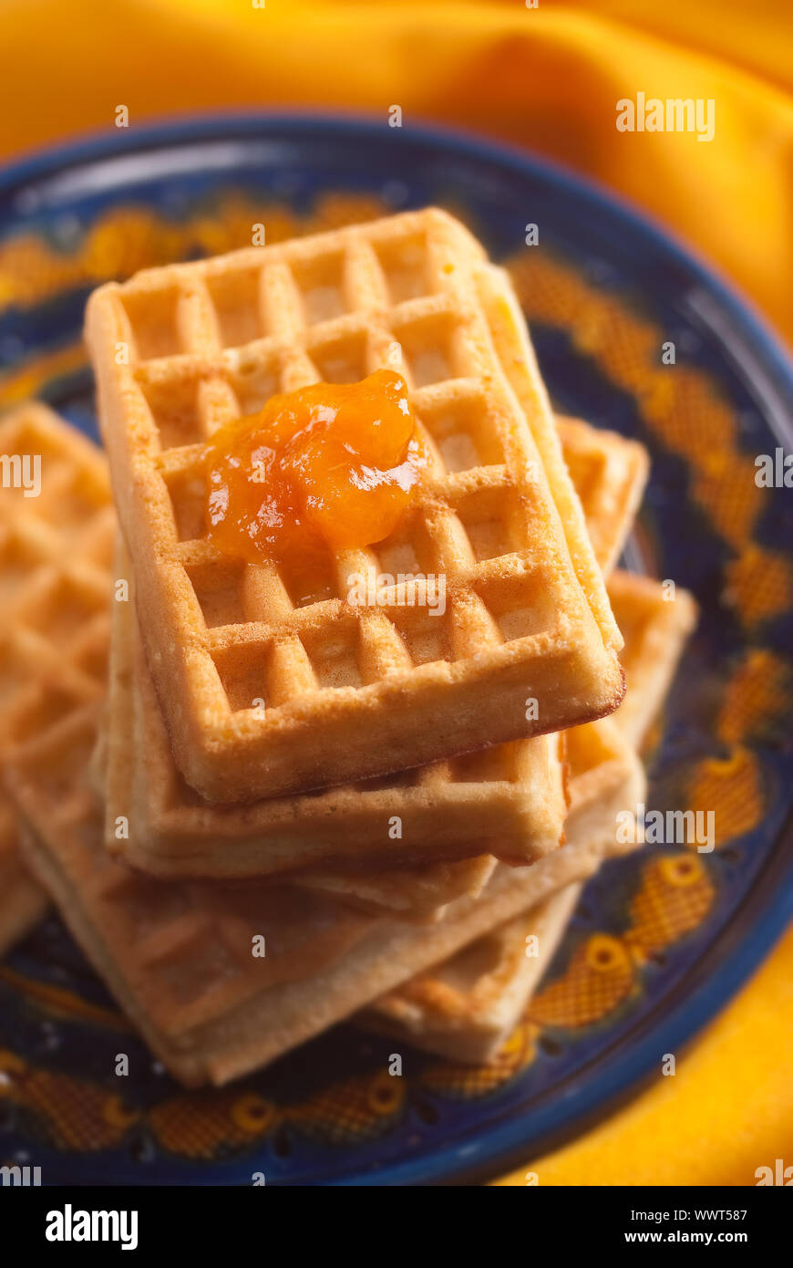 Confettura di albicocca sul belga cialde impilate su una piastra di blu e arancione igienico Foto Stock