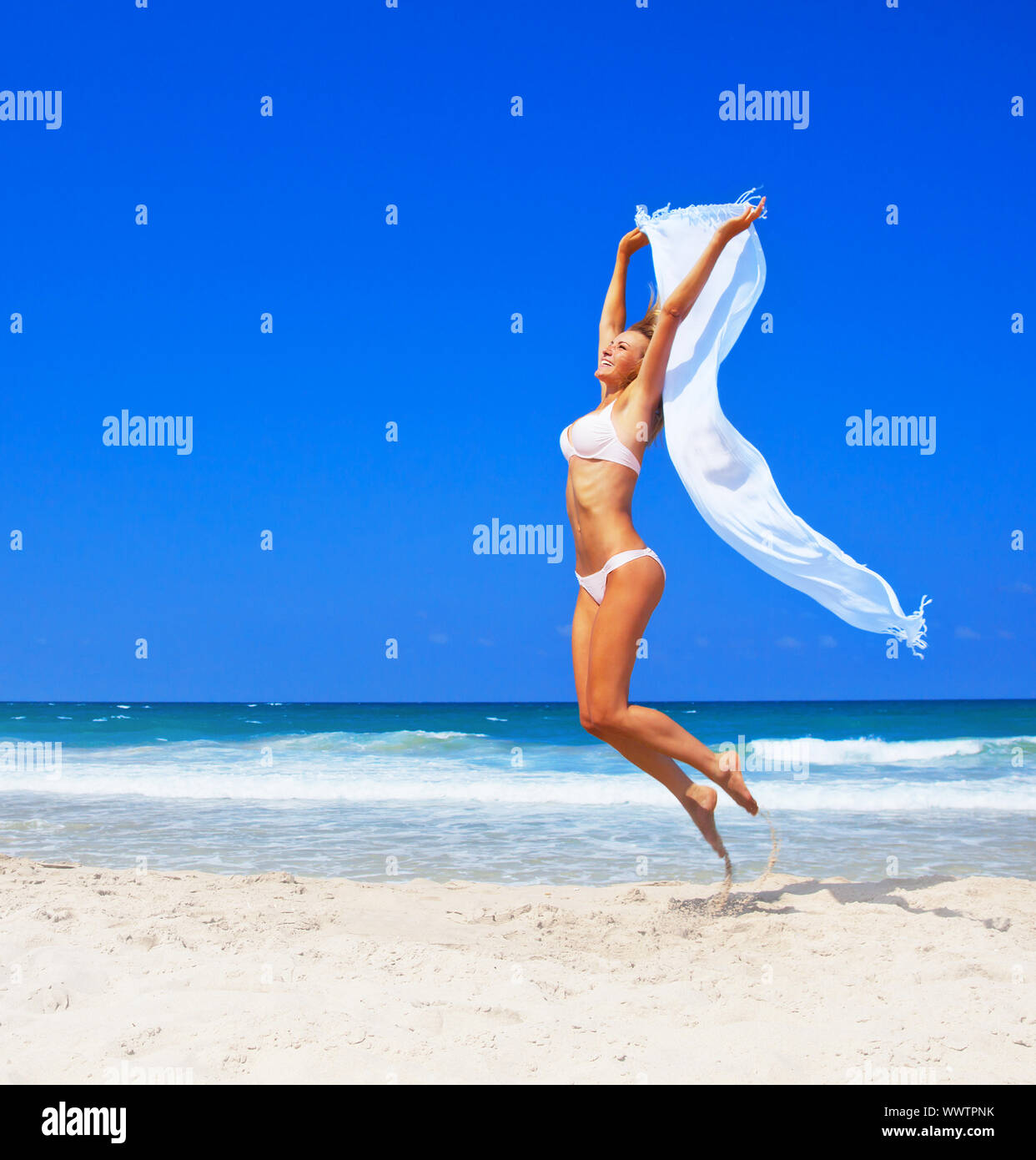 Jumping happy girl sulla spiaggia Foto Stock