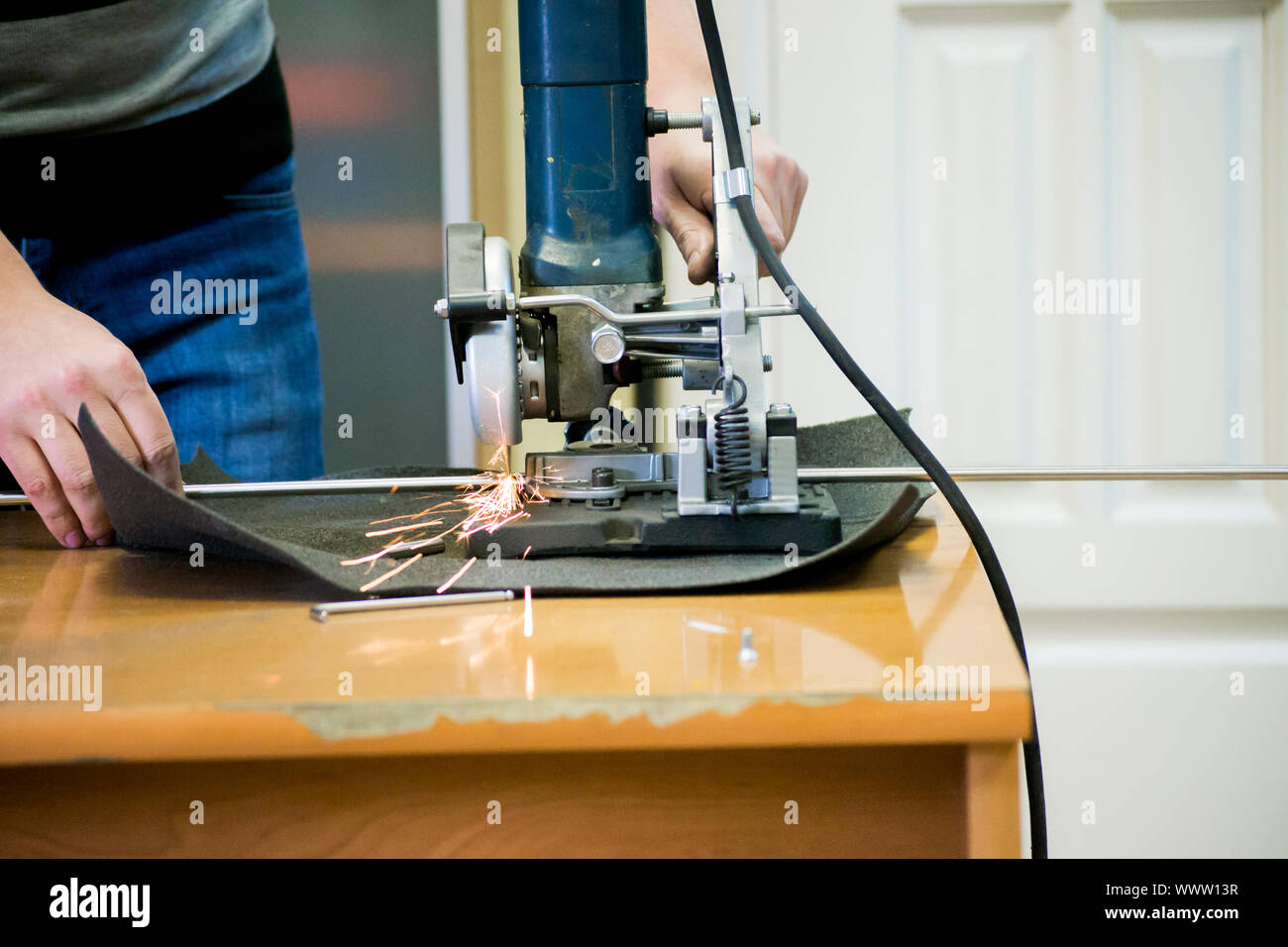 Lavoratore uomo taglio di un tubo metallico in due pezzi di close-up. Foto Stock