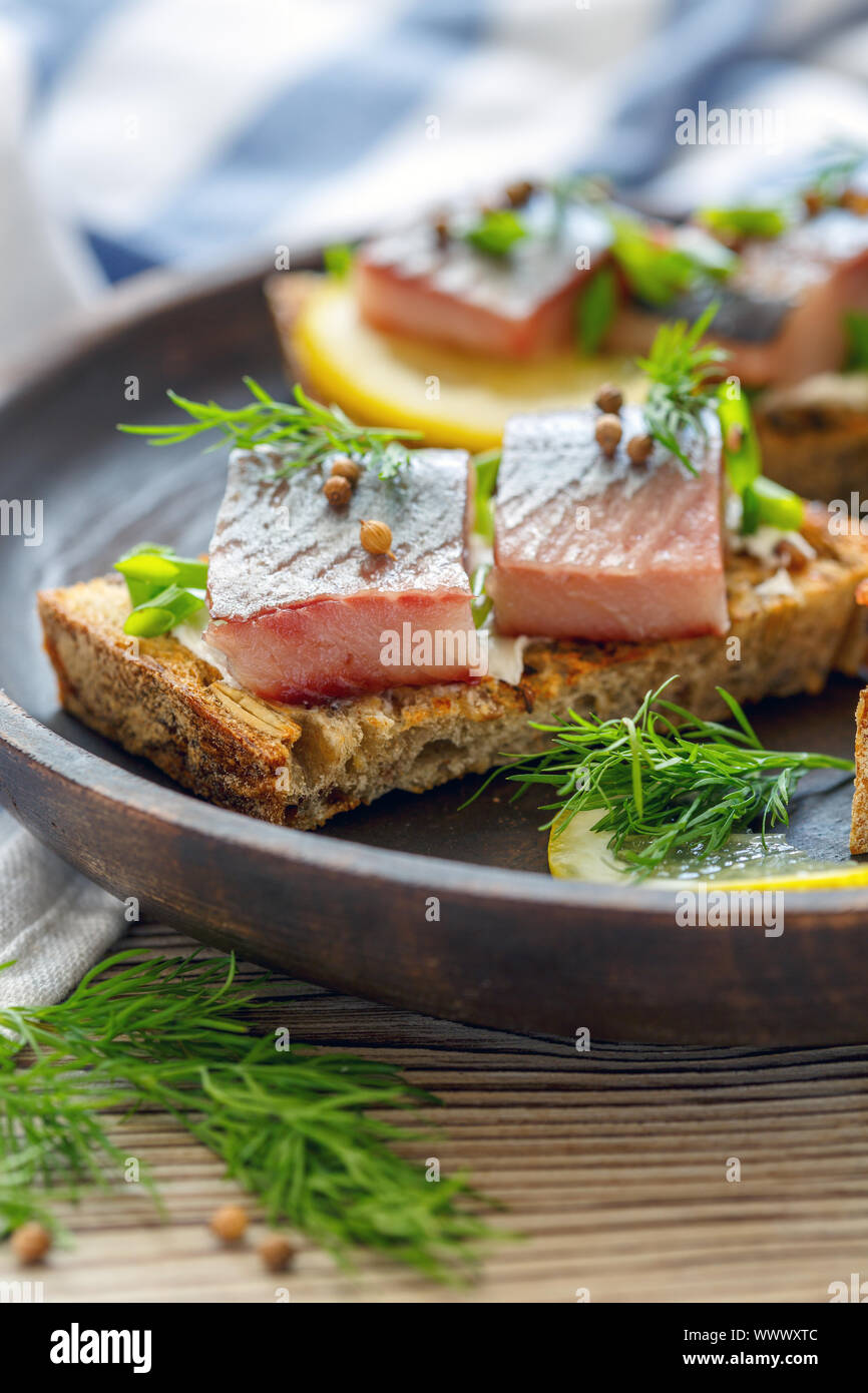 Pane tostato con ricotta, pezzi di aringhe e cipolle verdi. Foto Stock