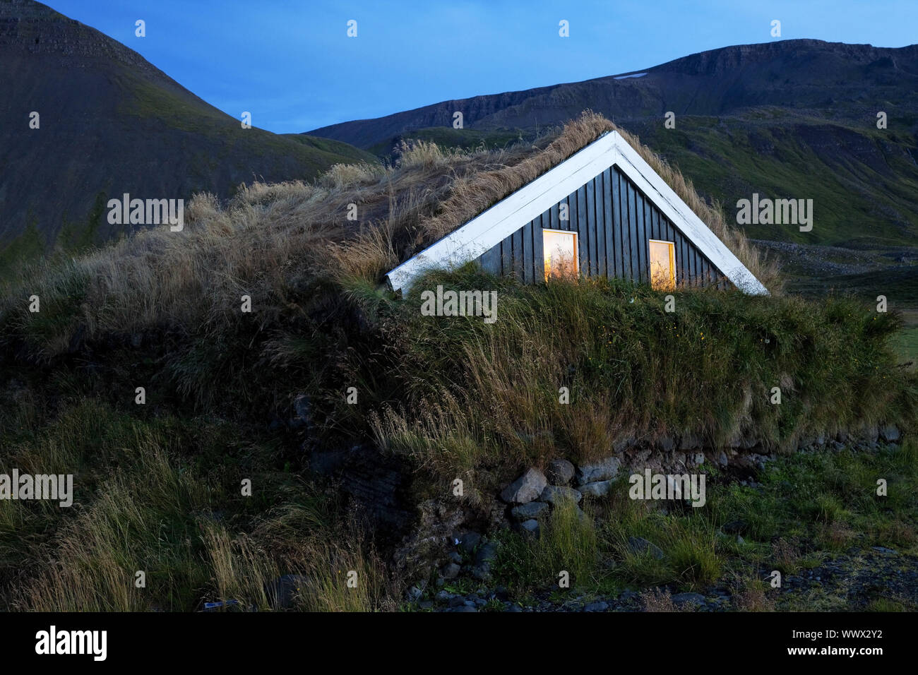 Capanna in legno con tetto del fondo erboso nella luce della sera, Reykjadiskur, Skagafjoerdur, Islanda, Europa Foto Stock