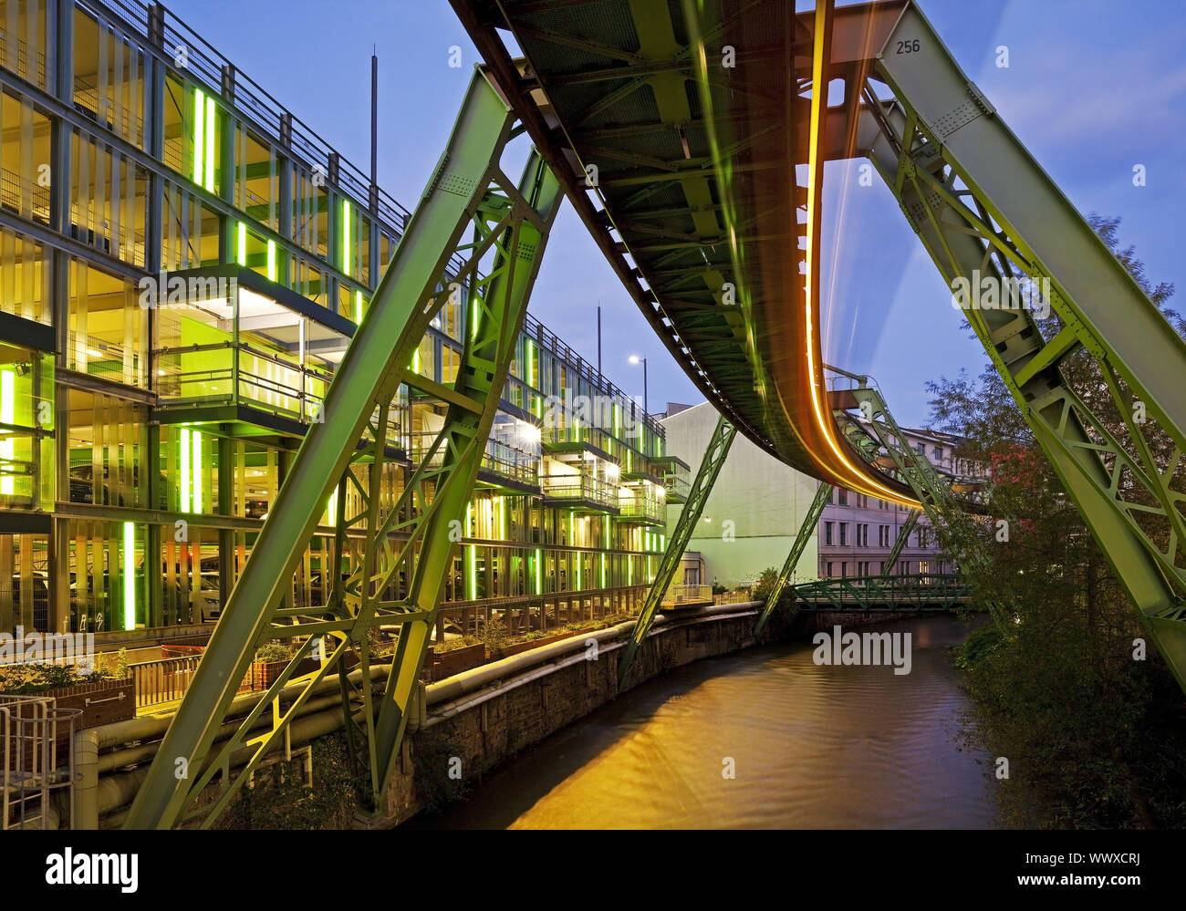 Striscia di luce della sospensione della monorotaia di Wuppertal oltre il fiume Wupper in serata, Germania, Europa Foto Stock