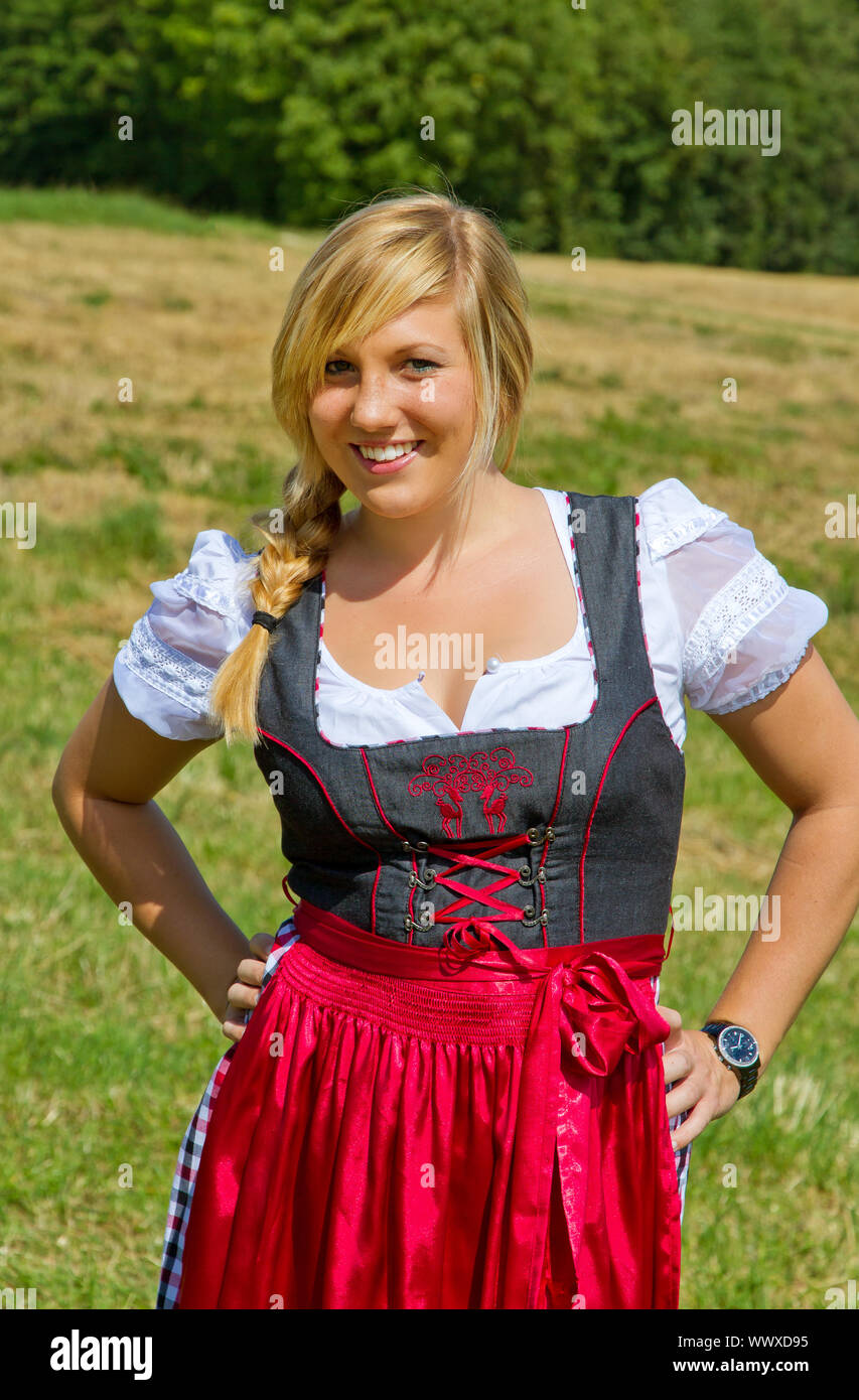 Giovane donna felice in un tradizionale tedesco dirndl nella natura Foto Stock