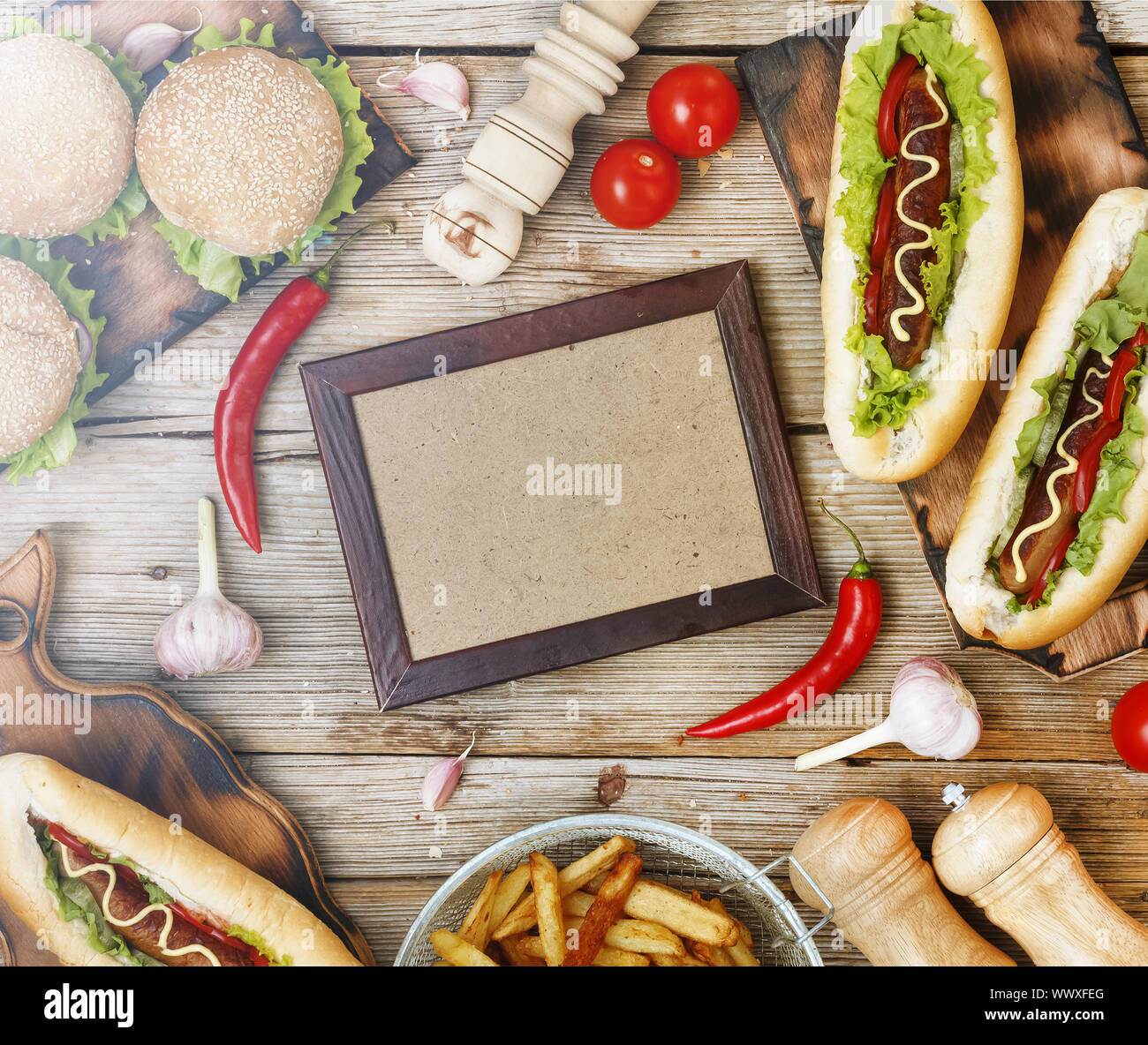 Varie fast food piatti sul tavolo da pranzo e al centro - un fotogramma vuoto per il testo o per visualizzare il menu Foto Stock