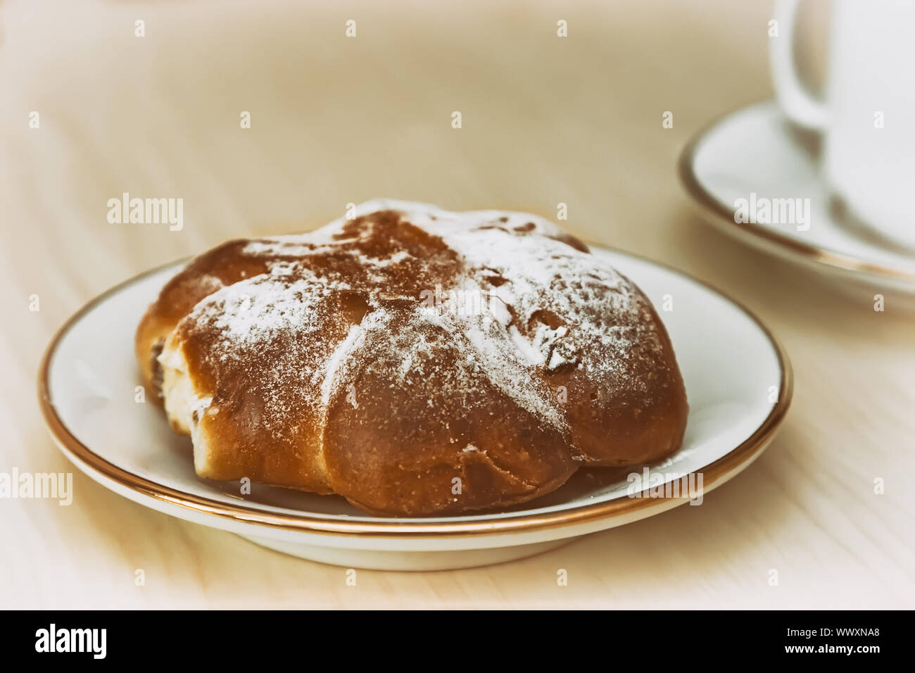 Una tazza di caffè e cannella rotolo su un tavolo di legno. Foto Stock