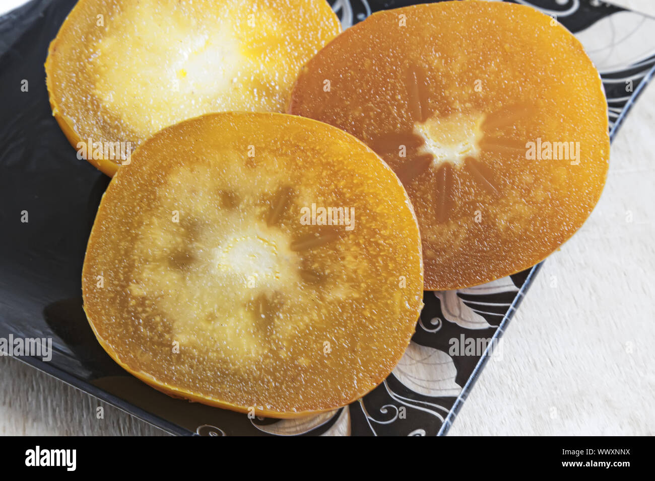 Le fette di persimmon sulla tavola su un piatto di vetro. Foto Stock