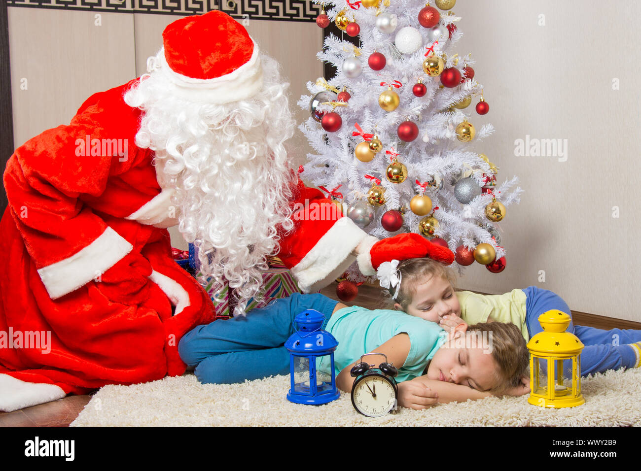 Babbo Natale ha portato regali e da un colpetto sulla testa di dormire i bambini Foto Stock