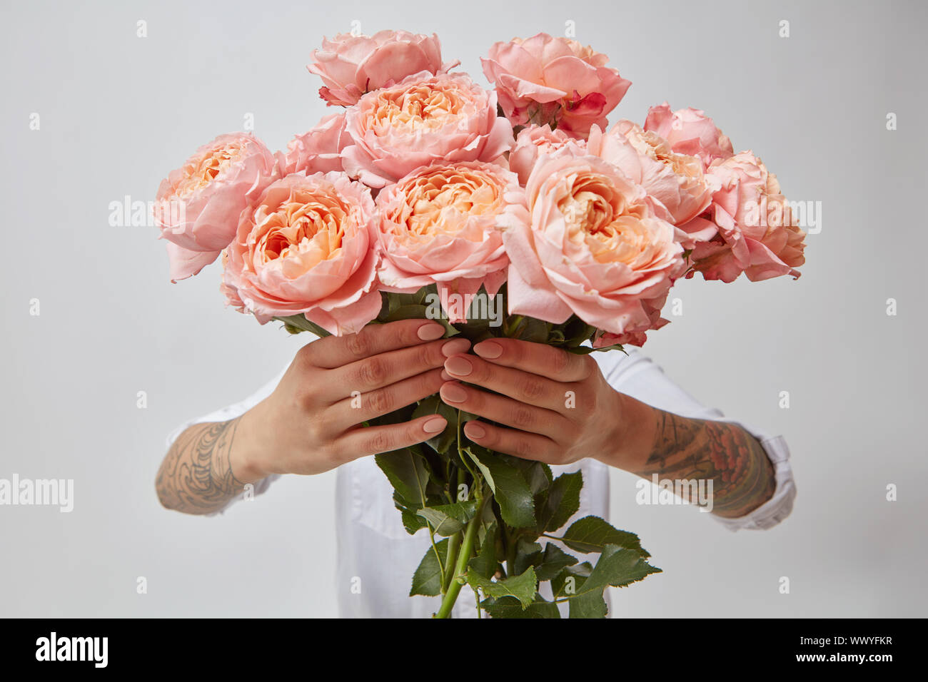 La ragazza è in possesso di un mazzo di fiori di rosa fresca roses, Foto Stock