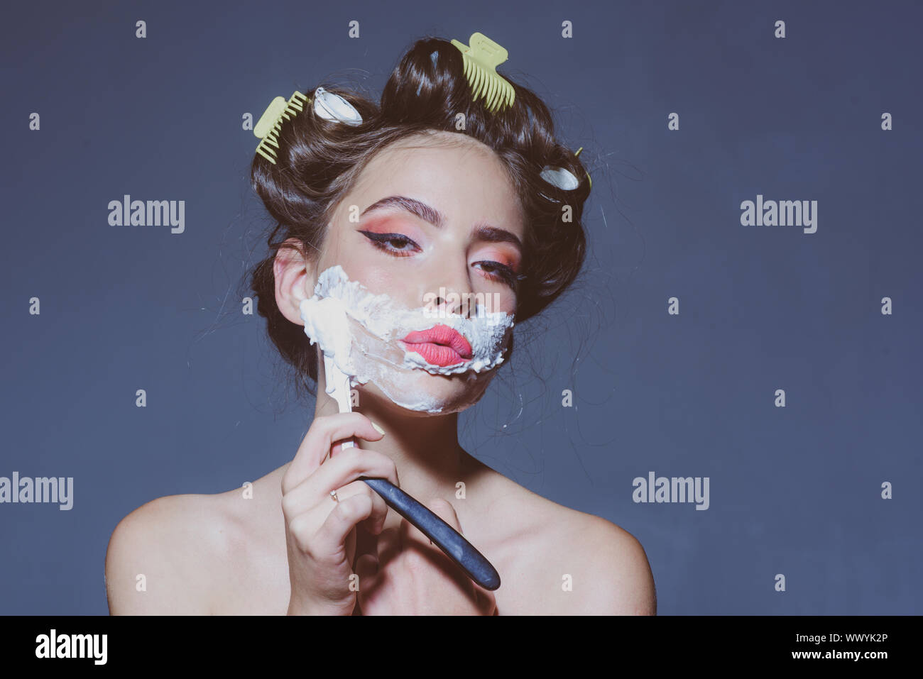 Mattina toelettatura e skincare. pin up donna con il trucco alla moda. retrò donna la rasatura con schiuma e una lama di rasoio. Pretty girl in stile vintage. pinup gir Foto Stock