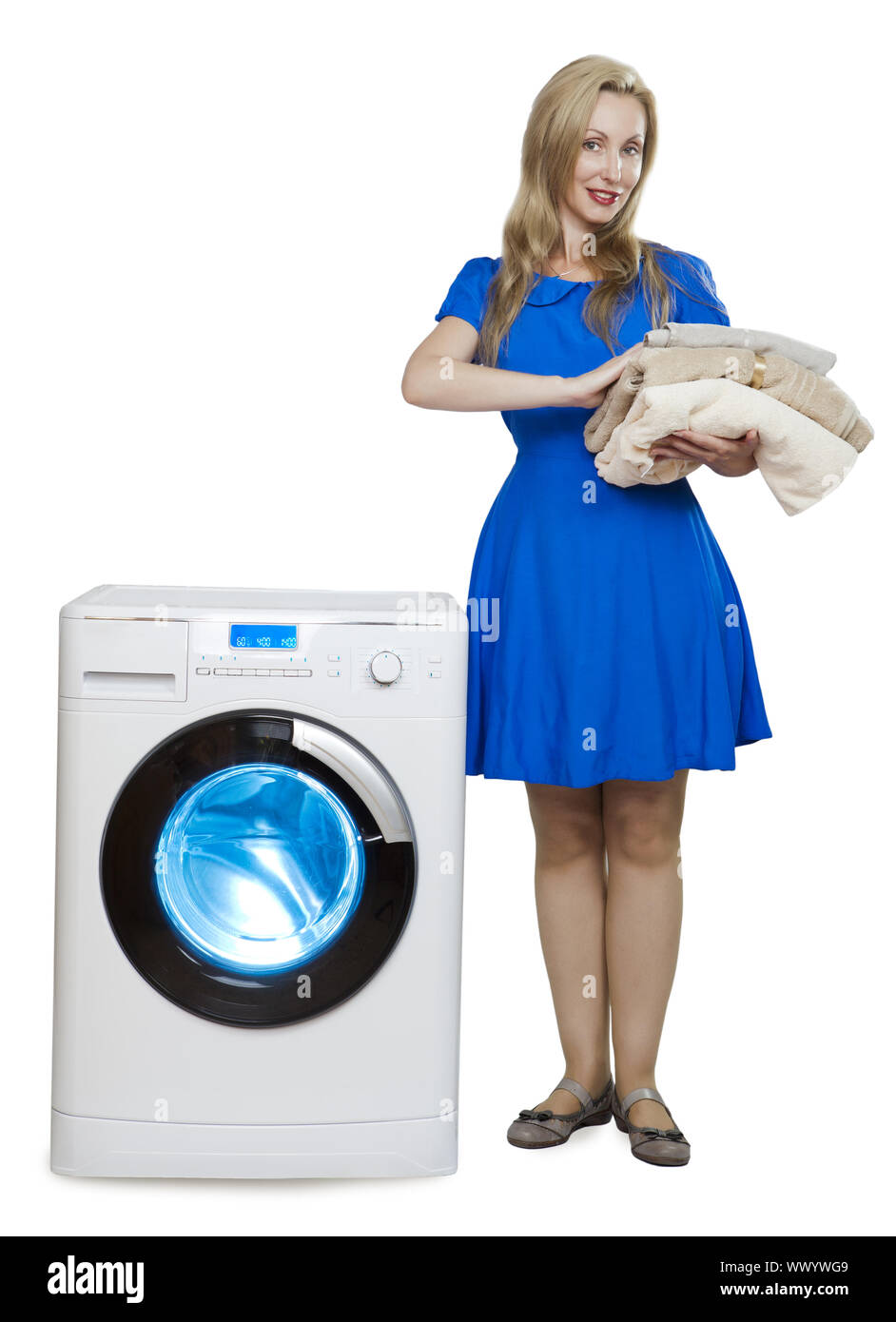 Felice giovane donna in un vestito blu vicino alla nuova macchina di lavaggio Foto Stock