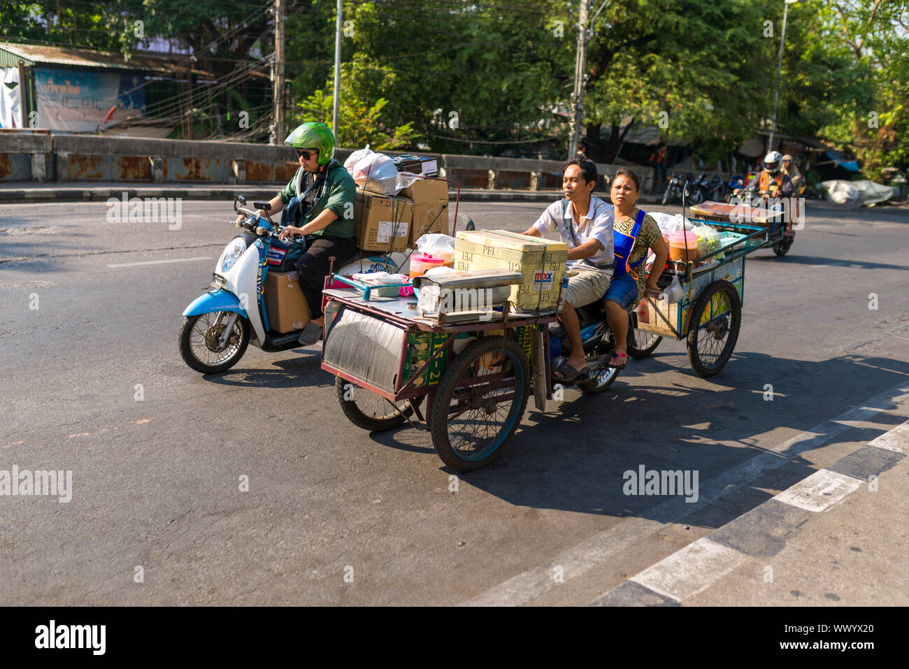 Giovane su uno scooter sul modo per i quartieri degli affari di vendere il cibo Foto Stock