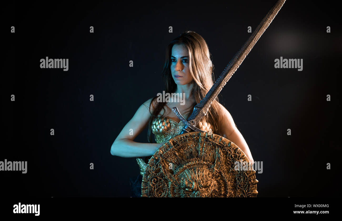 Knight valkyrie guerriero, donna con golden armor rivestire di ferro e grande guerriero spada Foto Stock