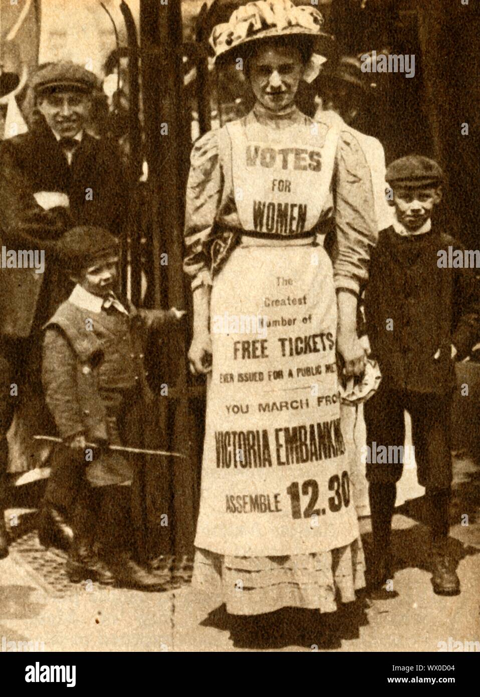 'L'Suffragette cameriera' 1908, (1933). Un suffragette (Vera Wentworth?) indossa una pubblicità pinafore una protesta a London Victoria Embankment. La campagna per fissare la votazione per le donne in Gran Bretagna ha visto le donne che adotta una serie di proteste, azione diretta e di disobbedienza civile, per il quale molti furono imprigionati. Suffragio parziale è stato raggiunto nel 1918 con tutte le donne infine ottenere il diritto di voto di dieci anni più tardi, nel 1928. Da "il corteo del secolo". [Odhams Press Ltd, 1933] Foto Stock