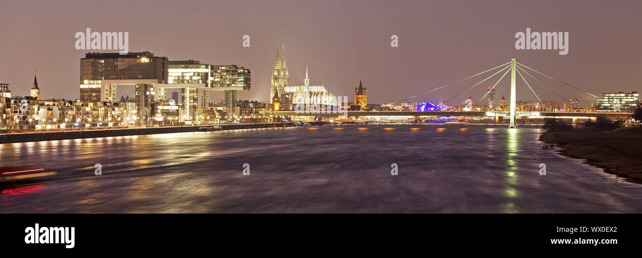 Costruzioni di gru a Reno con la cattedrale di Colonia al crepuscolo, Colonia, nella Renania, Germania, Europa Foto Stock