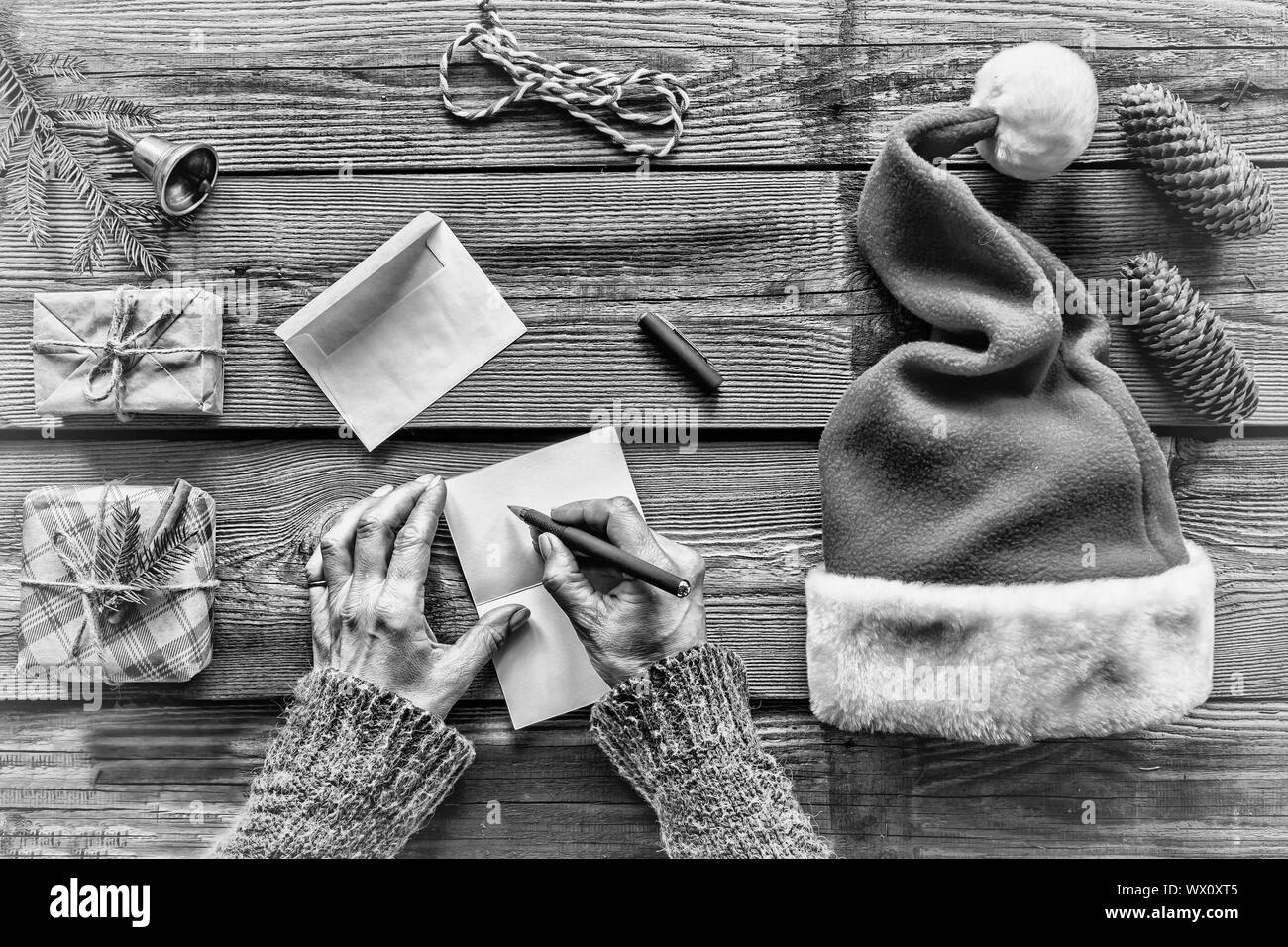 In bianco e nero. Concezione: Natale. Fare regali di Natale. l'uomo, scrive una lettera, Biglietti di auguri Foto Stock