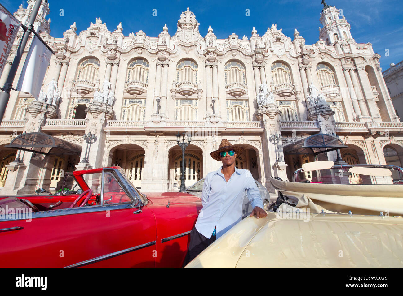 Taxi driver accanto alla sua auto d'epoca, di fronte al Gran Teatro de La Habana, Havana, Cuba, West Indies, dei Caraibi e America centrale Foto Stock