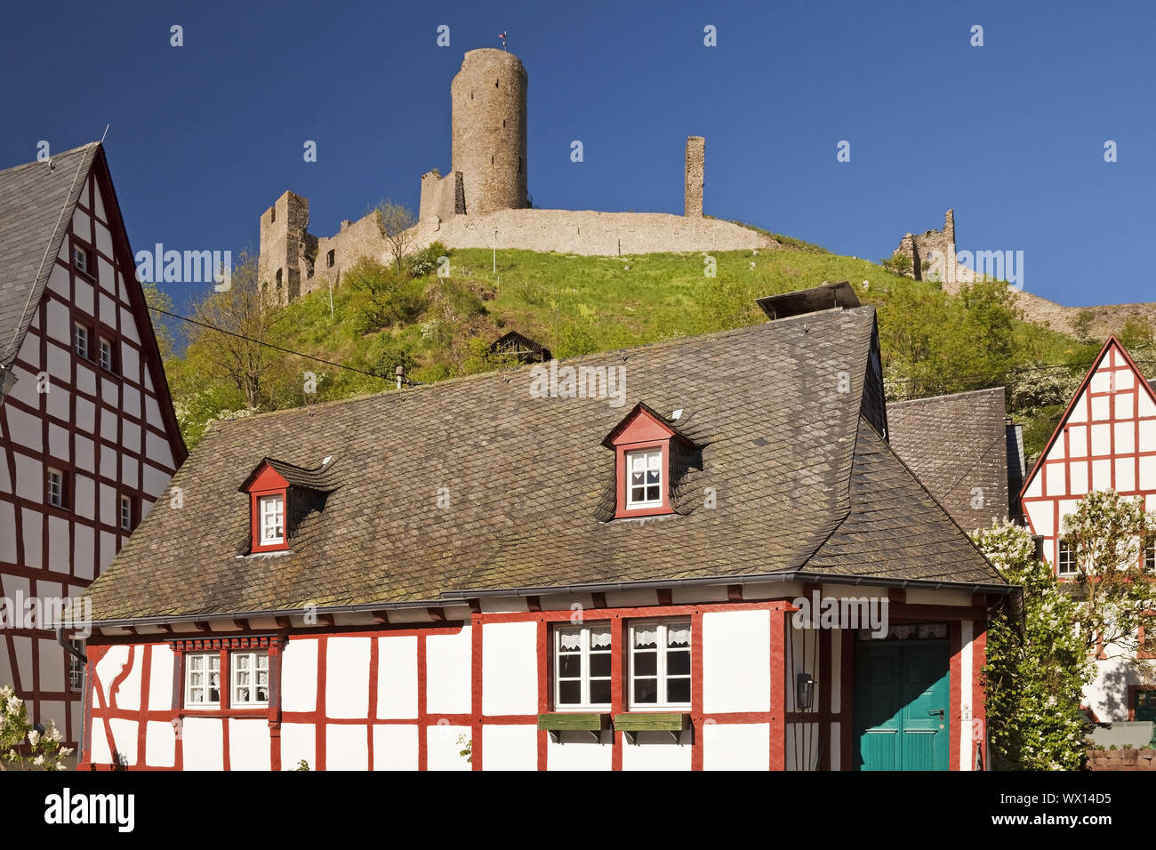 Centro storico della città con tipiche case a graticcio e le rovine del castello di Lion, Monreal, Germania Foto Stock