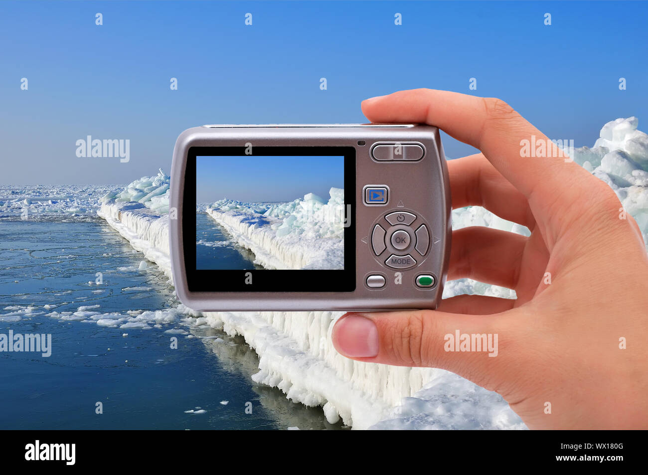 Macchina fotografica in mano di fotografare il molo di ghiaccio Foto Stock