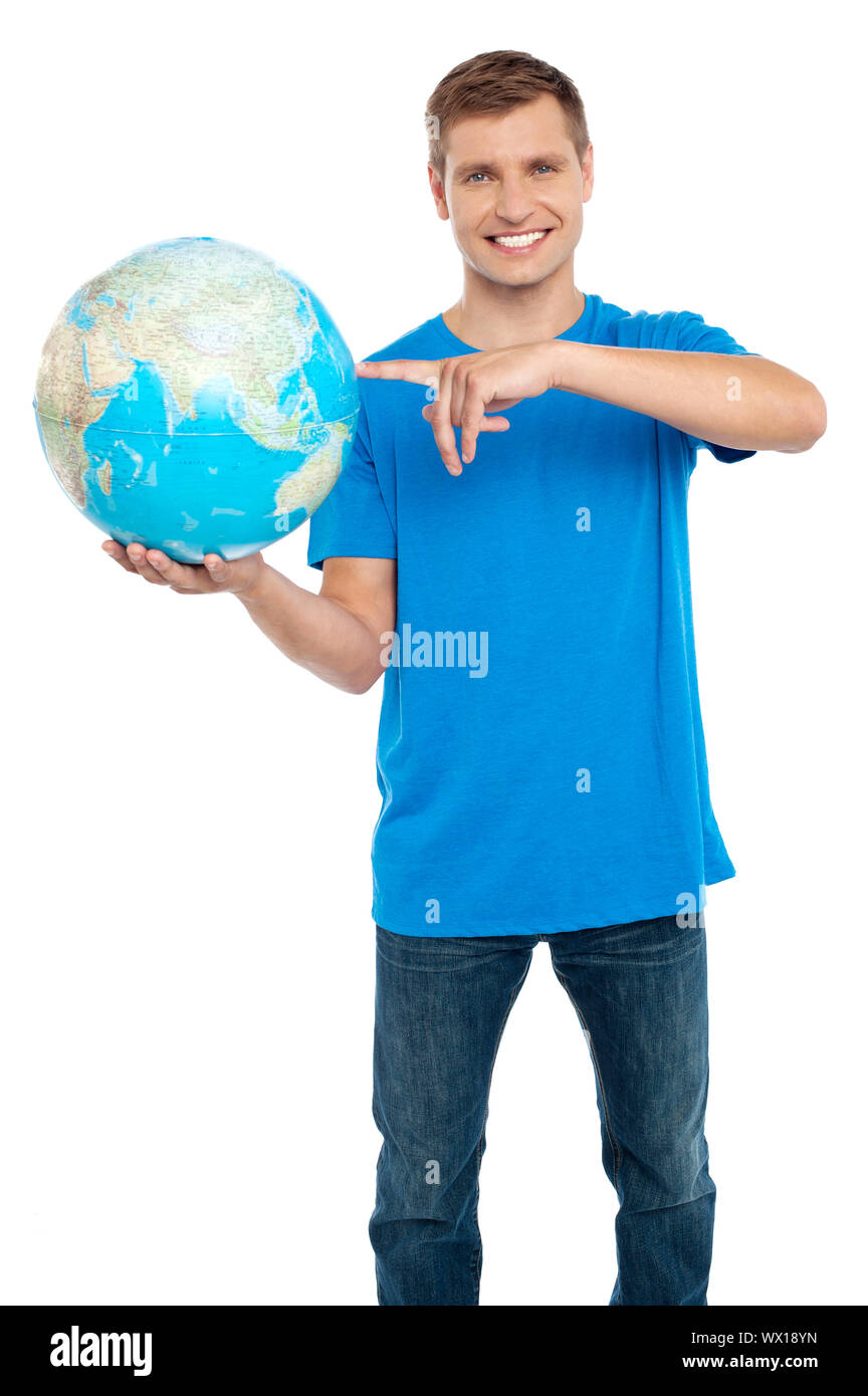 Smart guy puntando verso il mondo. Vestito di casuals. Isolato su bianco Foto Stock