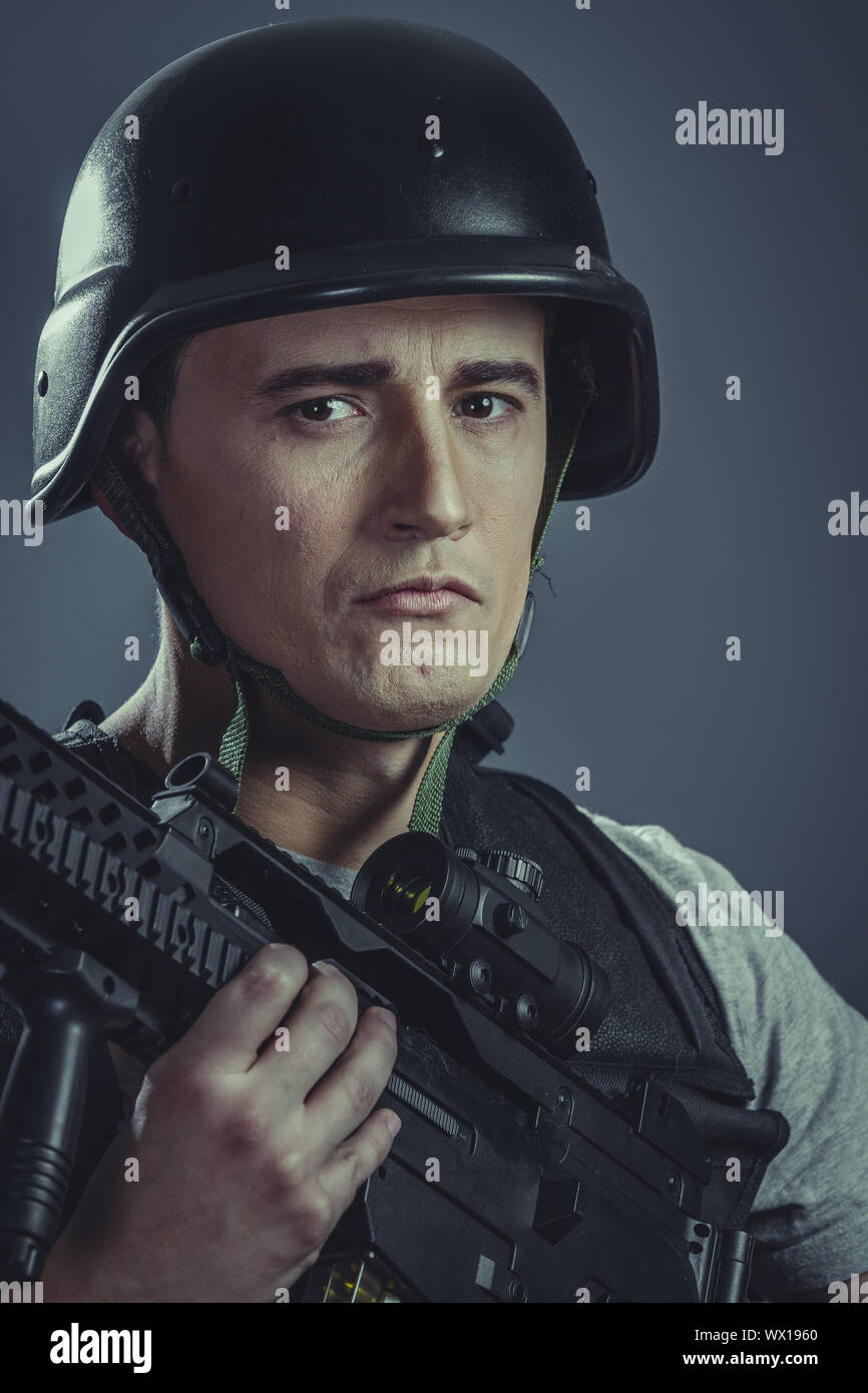 Paintball giocatore indossa il casco protettivo pistola di puntamento ,black armor e mitragliatrice Foto Stock