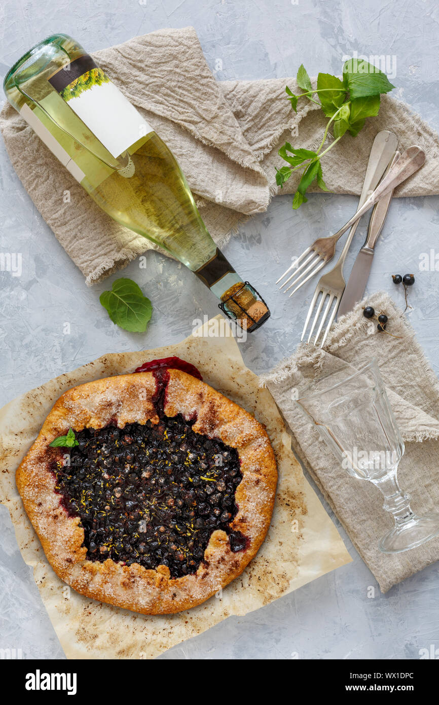 Berry pie (Galette), una bottiglia di vino bianco e un bicchiere. Foto Stock