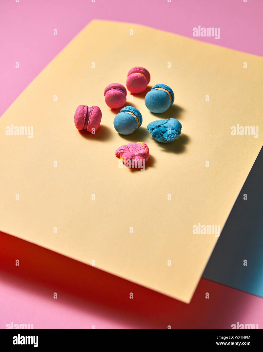 Composizione originale di amaretti colorati su un foglio giallo su sfondo della carta Foto Stock