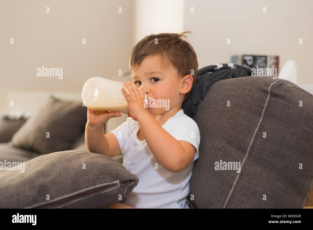 Adorable baby tenendo la bottiglia di latte Foto Stock