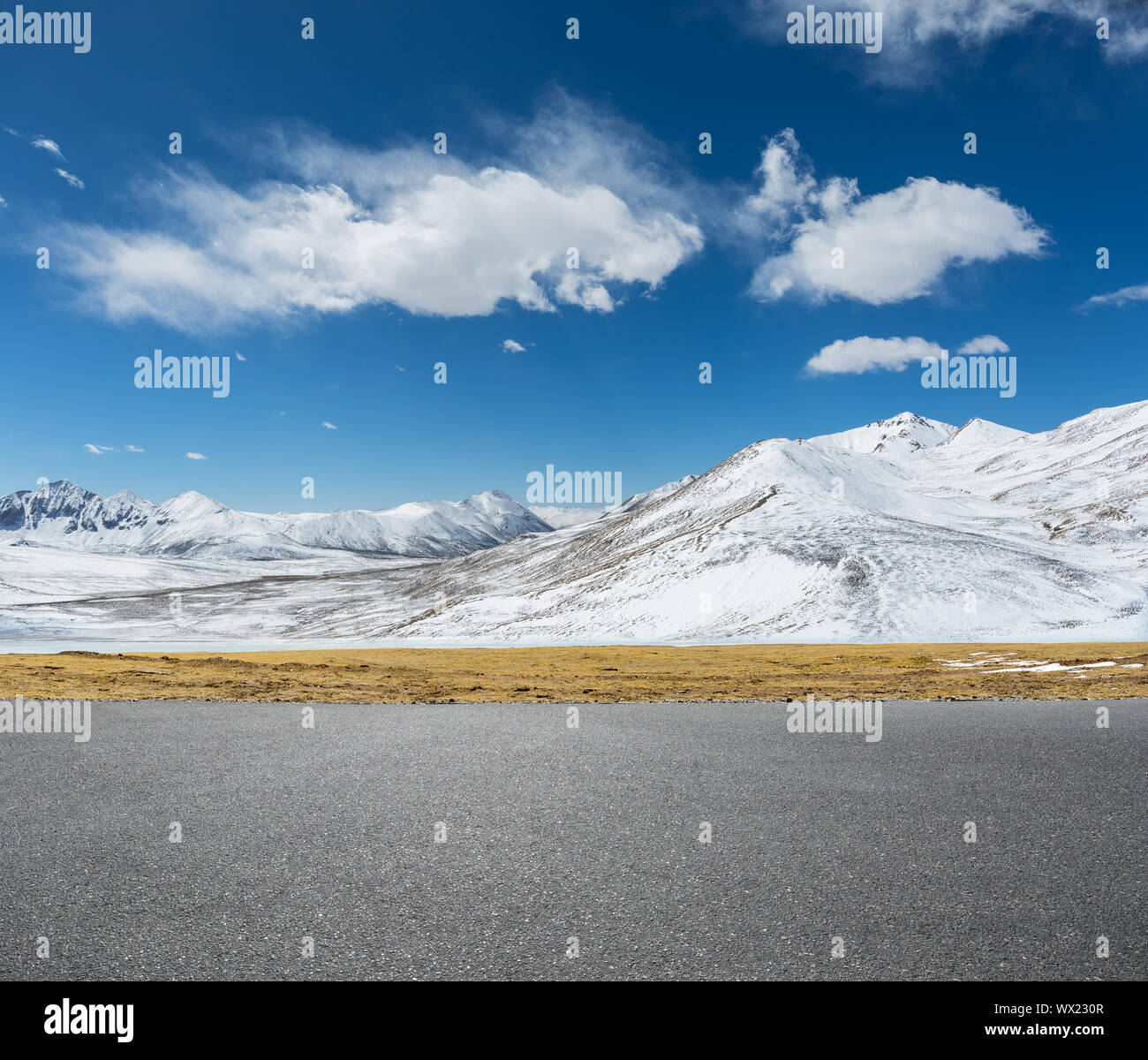 Svuotare strada asfaltata e la montagna di neve Foto Stock