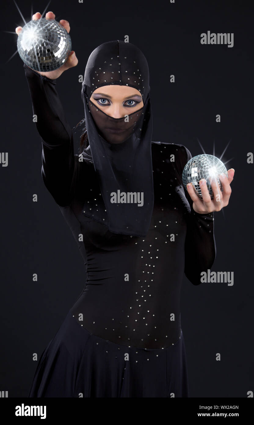 Parte ballerino in abito di ninja con sfere da discoteca Foto Stock