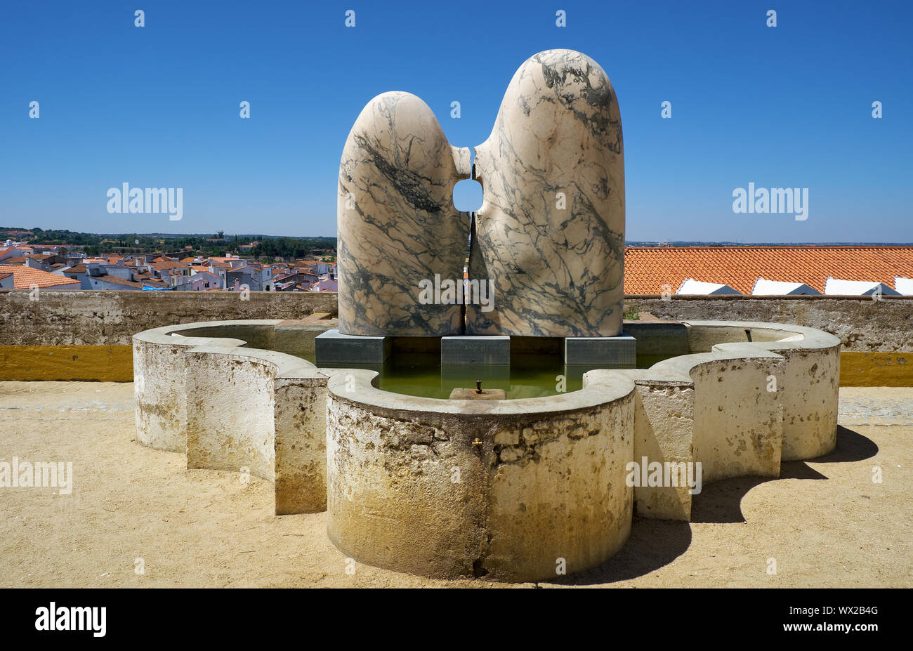 Una strada moderna arte scultura in marmo del giovane seduto vicino a Fontana al punto di vedetta del Giardino di Diana. Evora. Il Portogallo. Foto Stock