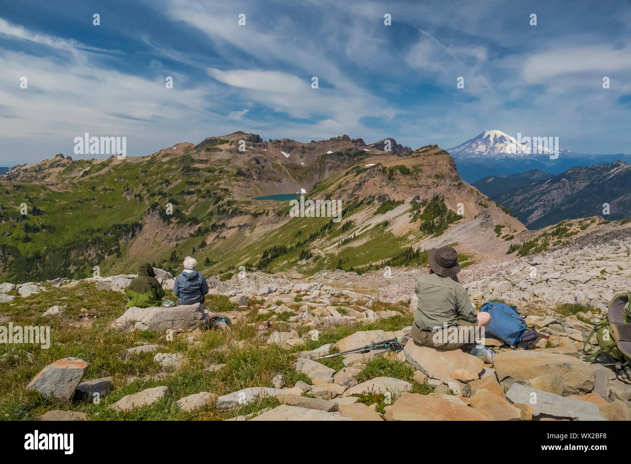 Gli escursionisti di capra di visione del Lago e Monte Rainier nelle rocce di capra deserto visto dal Pacific Crest Trail, Gifford Pinchot National Forest, Washingt Foto Stock