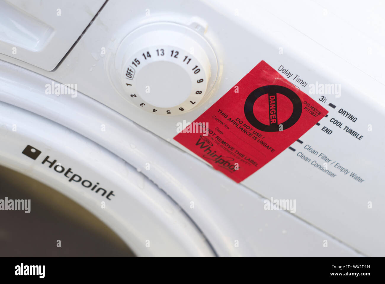 Pericolo Rosso segno bloccati sulla parte anteriore di un bianco Hotpoint  Whirlpool asciugatrice Foto stock - Alamy