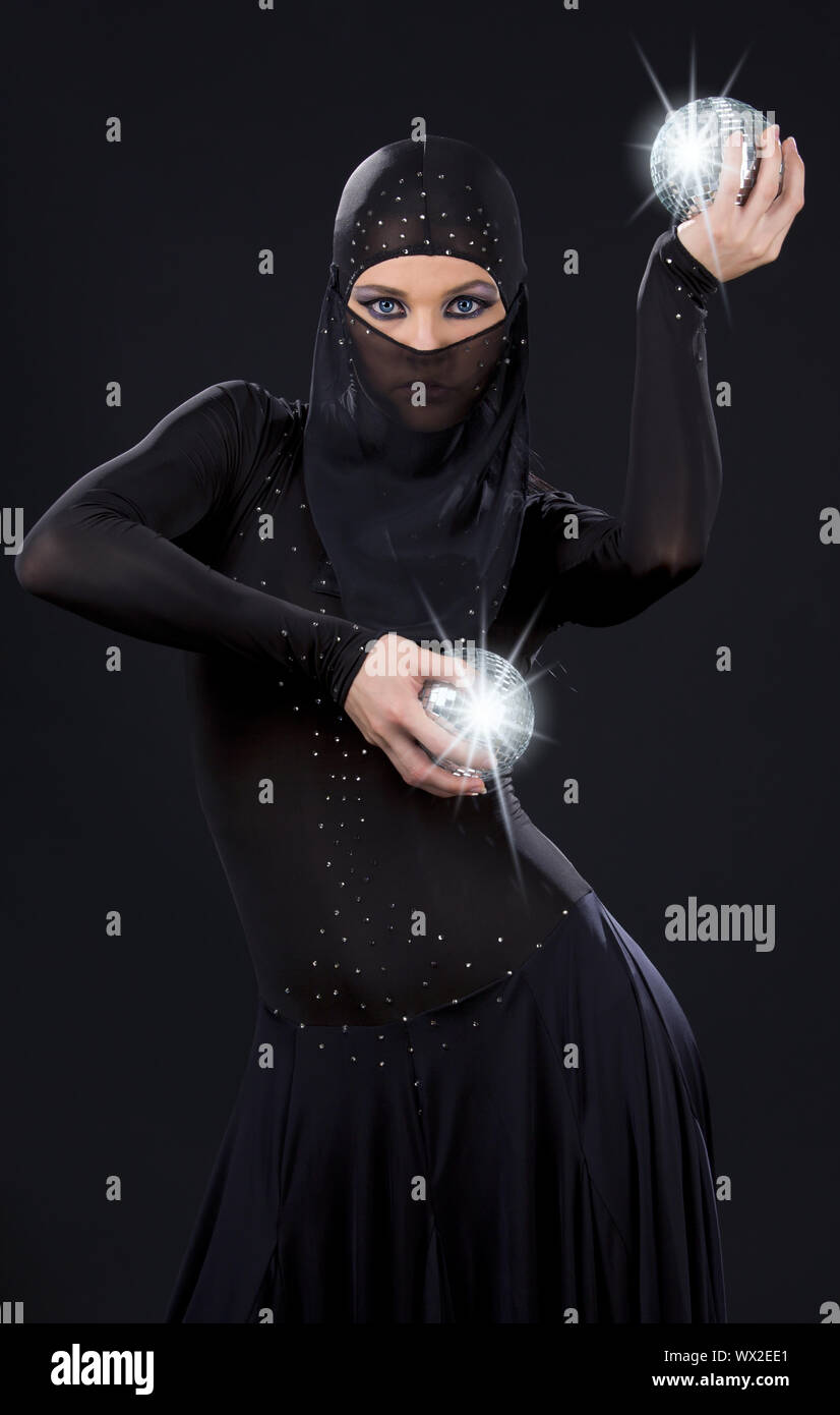Parte ballerino in abito di ninja con sfere da discoteca Foto Stock