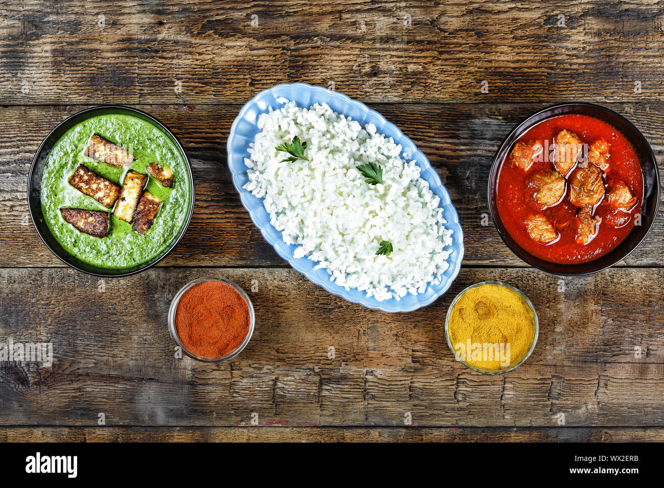 Pranzo indiano. Pollo al curry, pancake panier e riso su una tavola di legno, vista dall'alto, spazio di copia Foto Stock