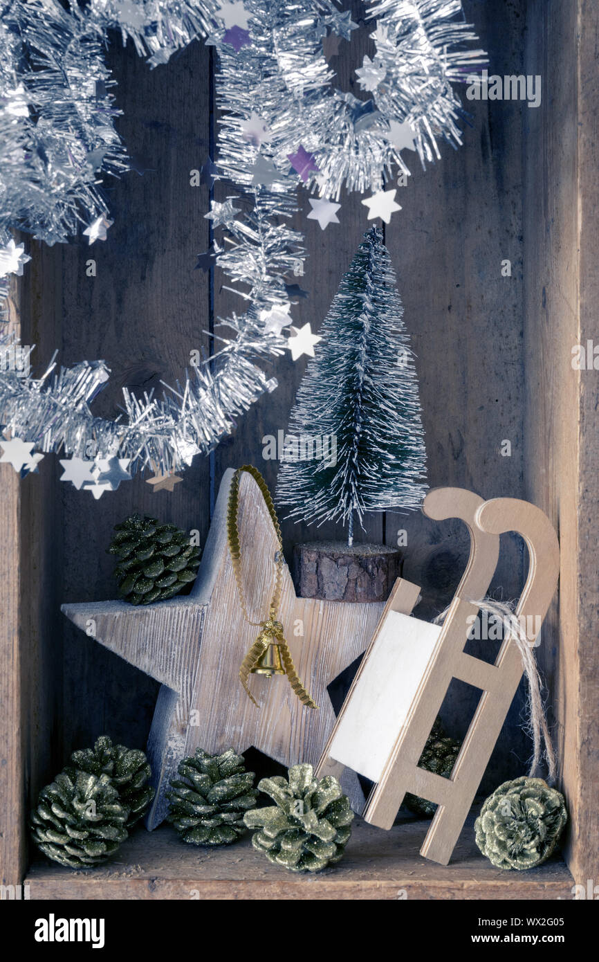 Decorazione di Natale golden campana, slitta, stella e albero in una scatola di legno sfondo Foto Stock