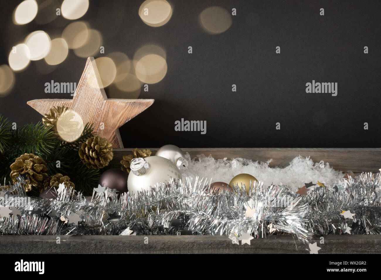 Decorazione di natale con sfere di vetro stella di legno e bokeh sfondo luci Foto Stock