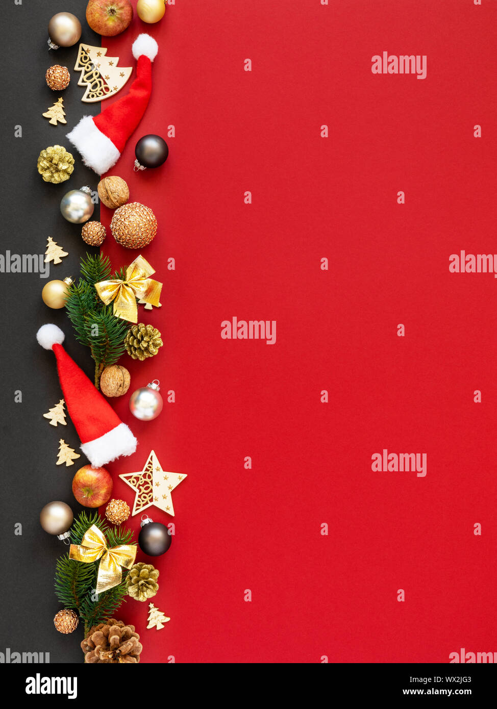 Decorazione di Natale sfondo rosso con cappelli di Babbo Natale palle di vetro ramoscello mele dadi Foto Stock