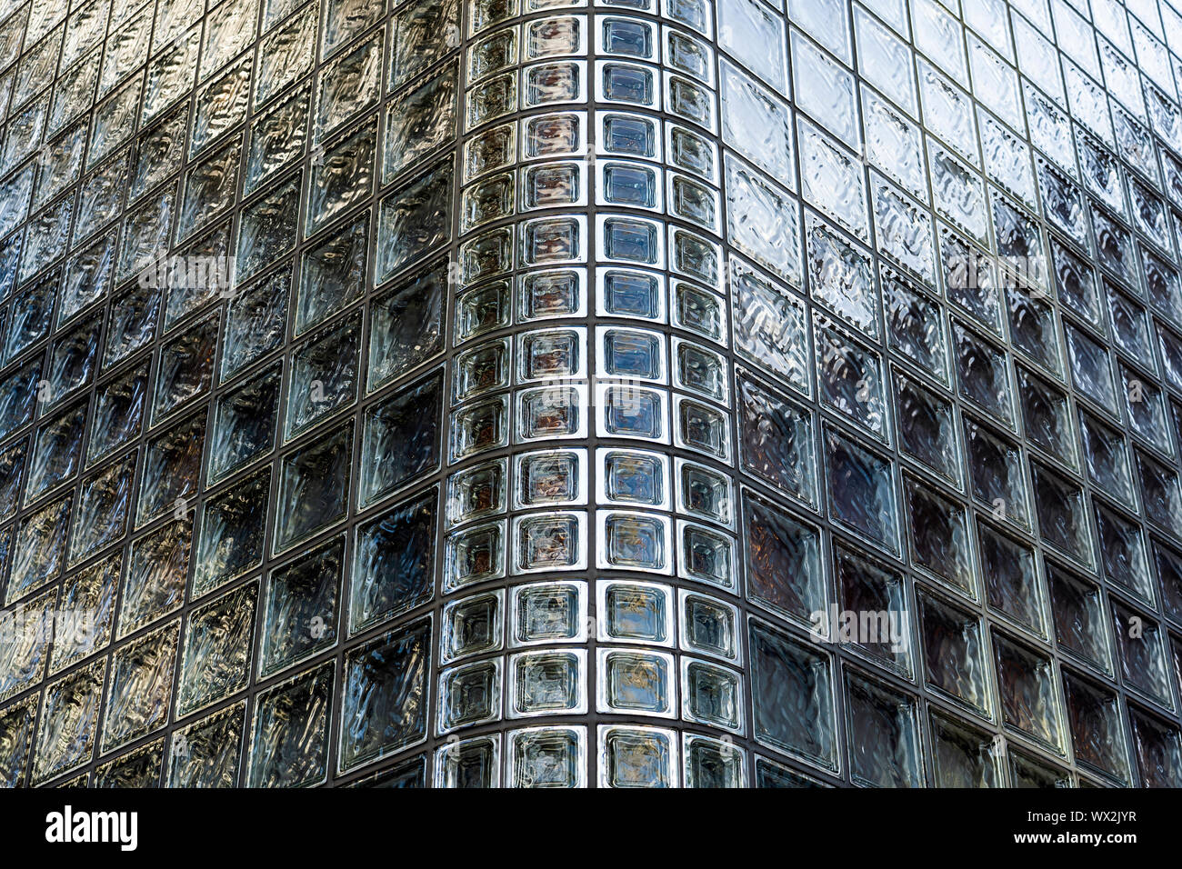 Vista ingrandita di blocchi di vetro. Angolo dell'edificio, costituito da mattoni in vetro. Muro di mattoni di luce. Foto Stock