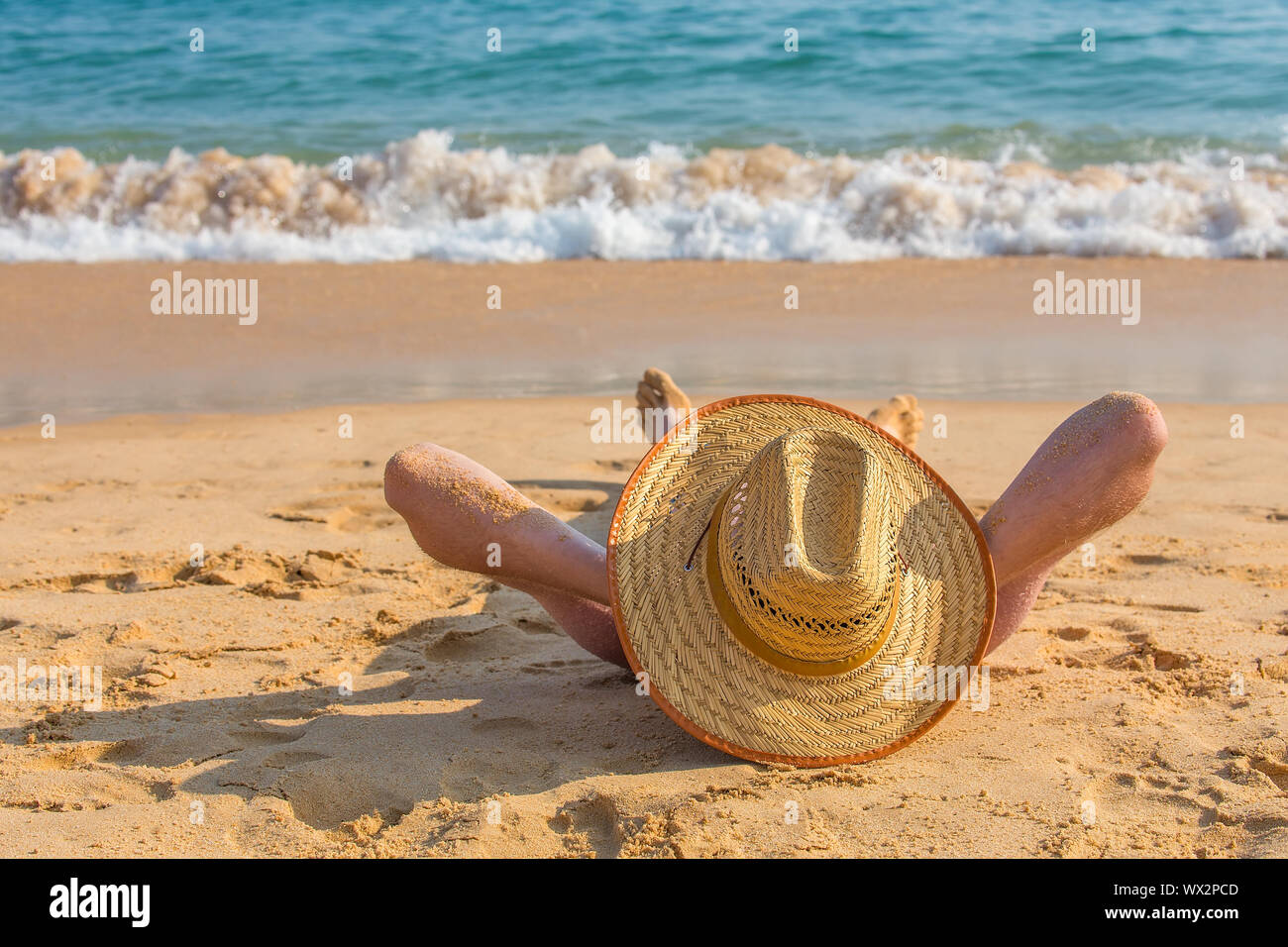 Giovane maschio tourist bagni di sole sulla spiaggia del mare Foto Stock